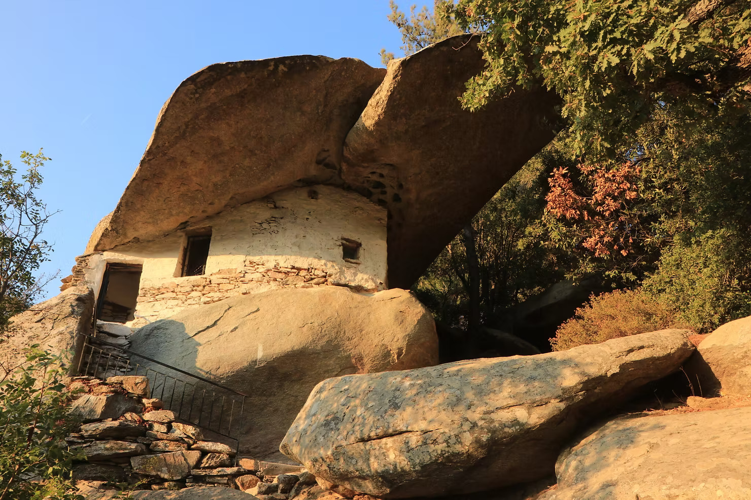 Pirate chapel built beneath a giant overhanging rock in Ikaria at golden hour